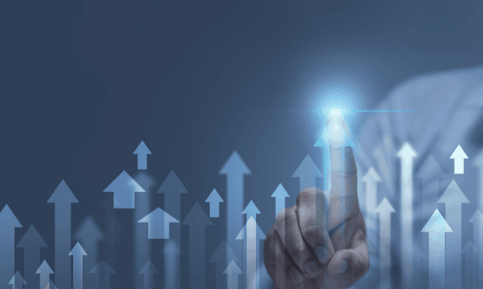 Person in business attire touching rising arrows, symbolizing growth, scalability, and integration for capsule filling production.