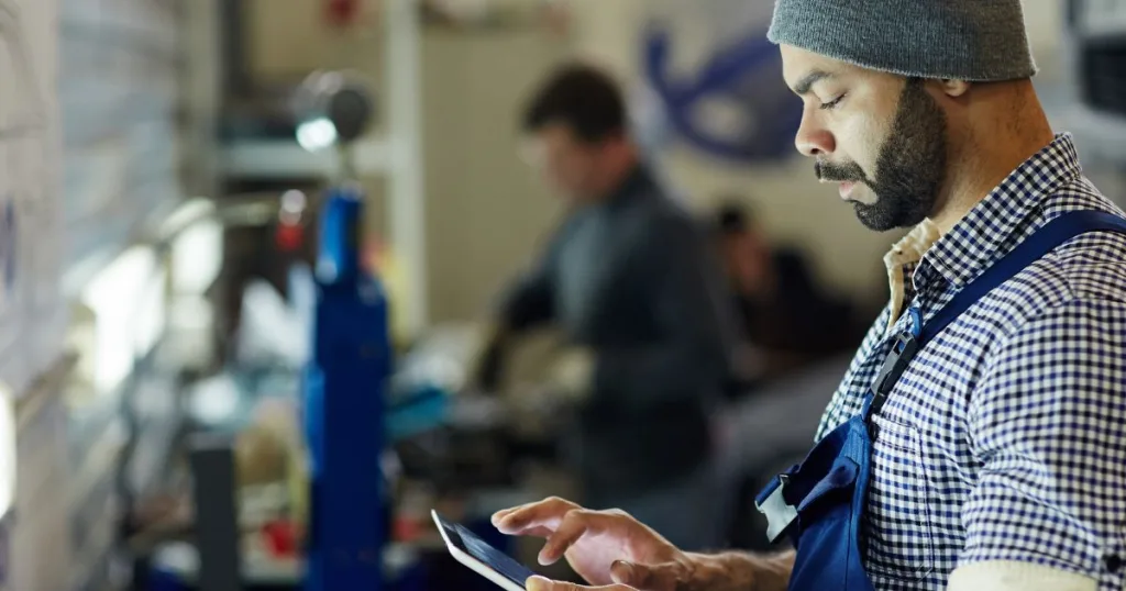 A warehouse technician managing capsule spare parts inventory with a tablet device.