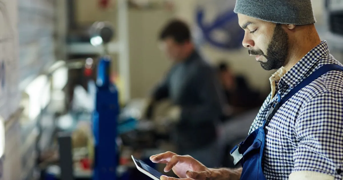 A warehouse technician managing capsule spare parts inventory with a tablet device.