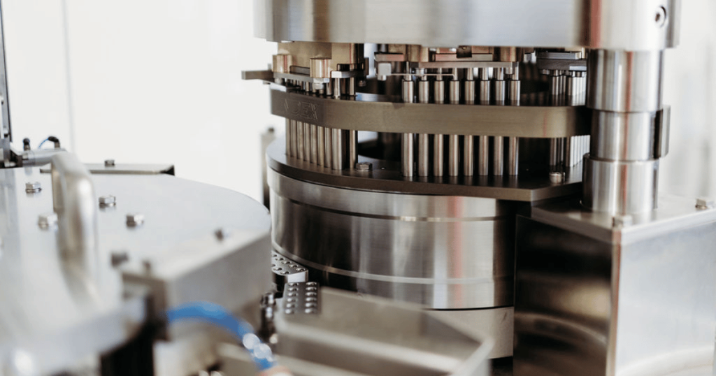 A close up shot of the Index K120i capsule filler machine tamping pins in the tamping section.