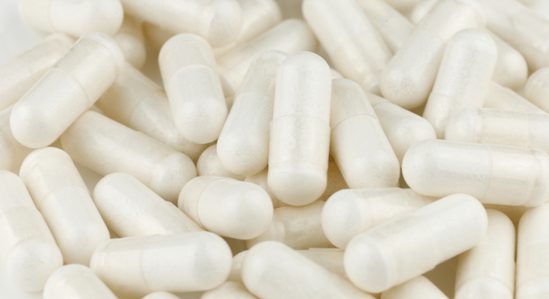 Close up shot of a pile of white capsules.