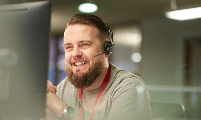 Bearded support specialist wearing a headset, providing reliable customer service for capsule filling solutions.
